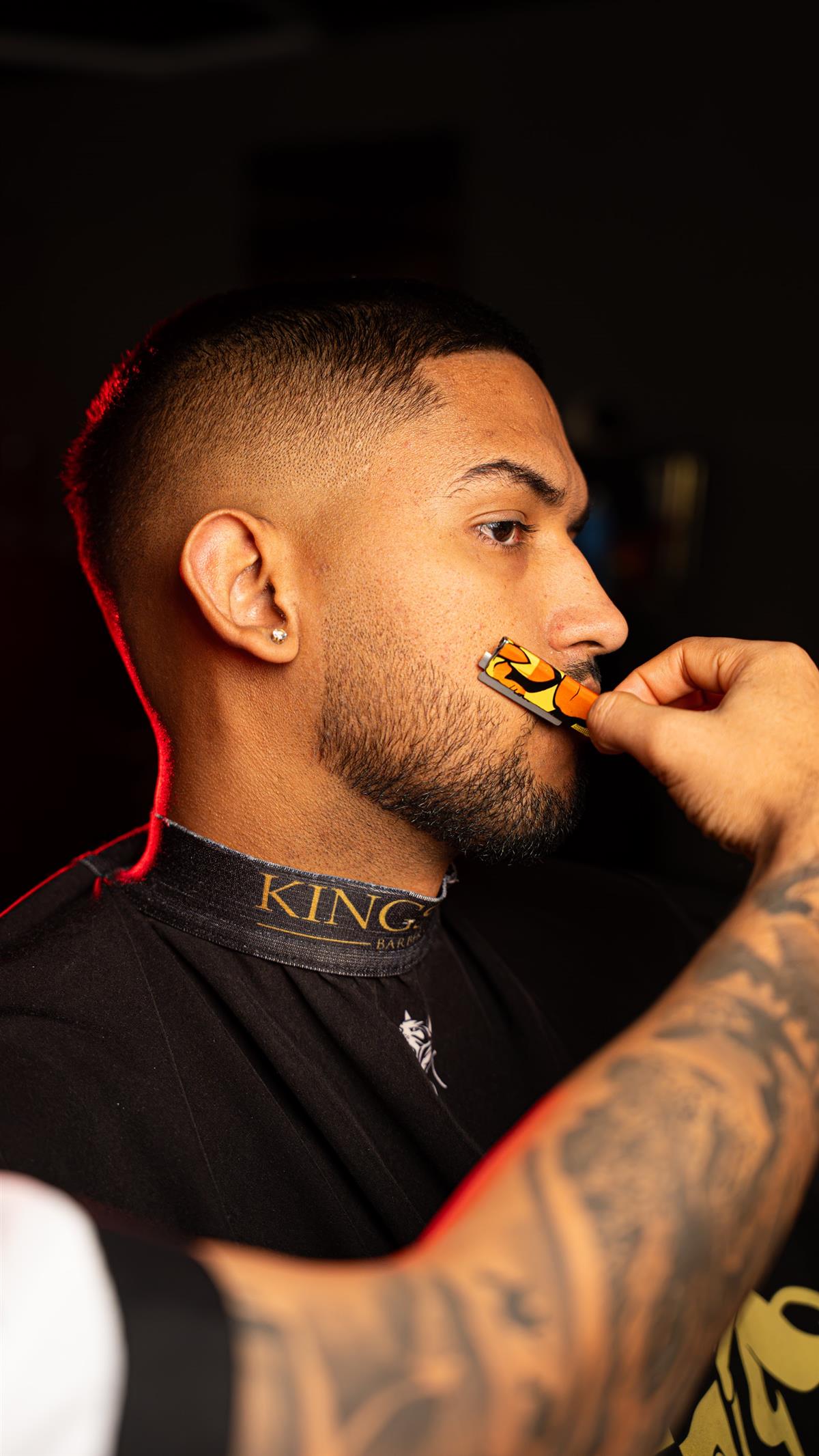 Cliente peinando su barba con un peine dorado